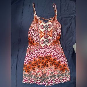 Women’s medium romper with pockets. Assortment of patterns. Criss-cross in back.